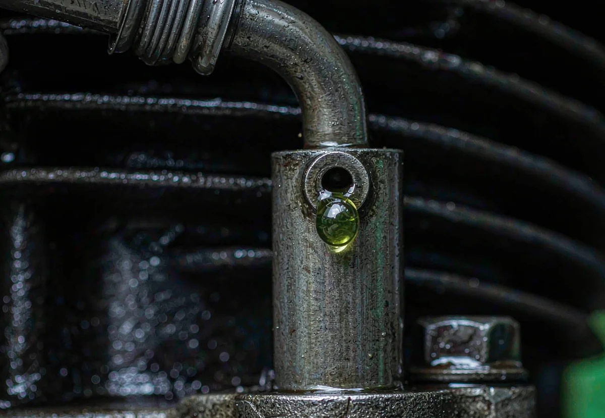 Close-up of a water pump weep hole with a small coolant leak