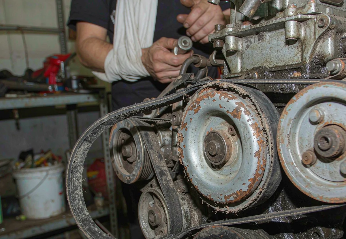 Worn water pump pulley and serpentine belt misalignment on an engine
